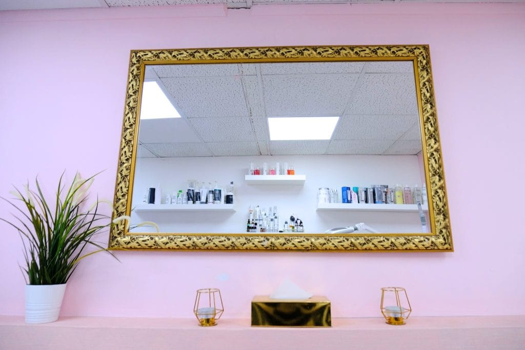 Pink treatment room with gold mirror at Maryam Hair & Beauty