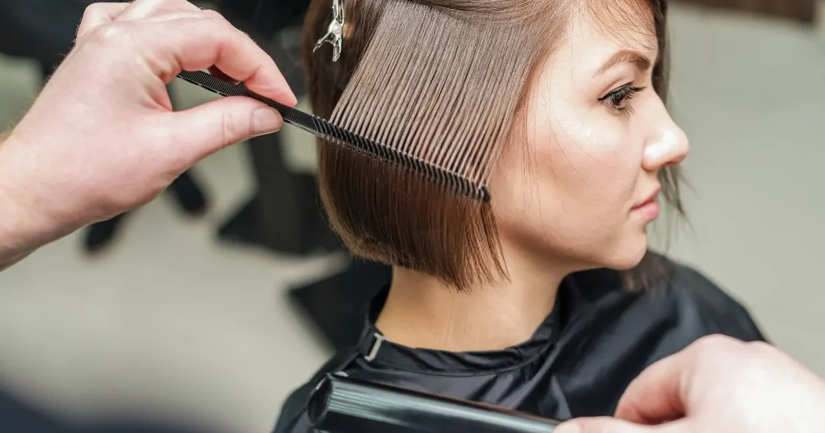 Hairdresser styling a client's hair at Maryam Hair and Beauty Salon in London, offering affordable and high-quality haircuts in the UK.
